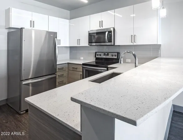 a kitchen with stainless steel appliances a refrigerator microwave stove and sink