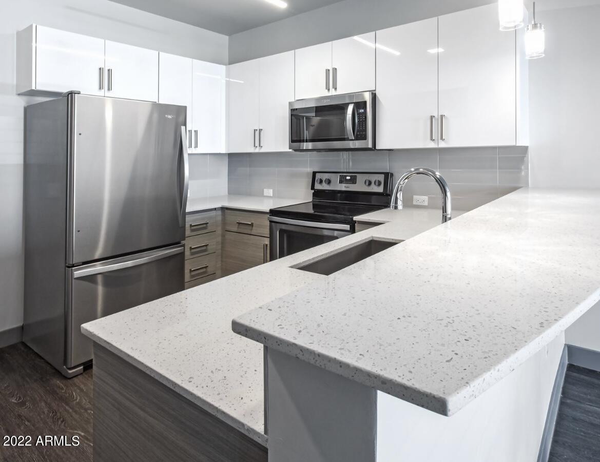 425 West Osborn Road, Unit 318 Phoenix, AZ 85013 - Photo 7 of 29 a kitchen with stainless steel appliances a refrigerator microwave stove and sink