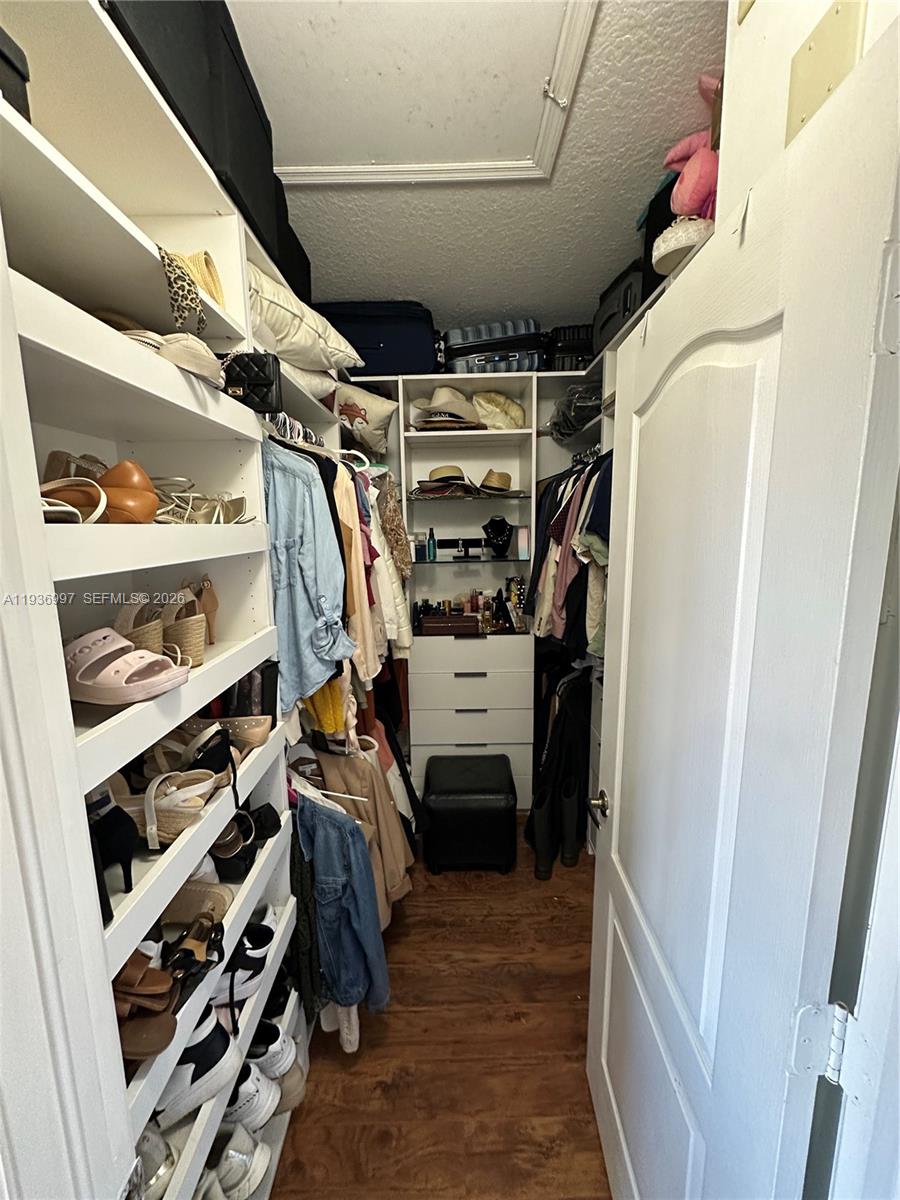 15313 Southwest 31st Terrace, Unit 15313 Miami, FL 33185 - Photo 13 of 21 a view of walk in closet with clothes and shoes