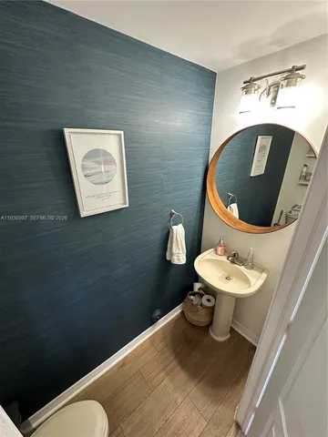 a bathroom with a toilet sink and mirror