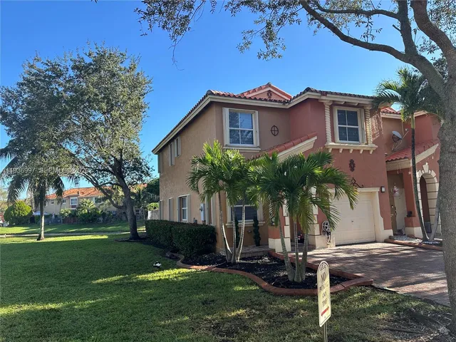 a front view of a house with a yard and a garage