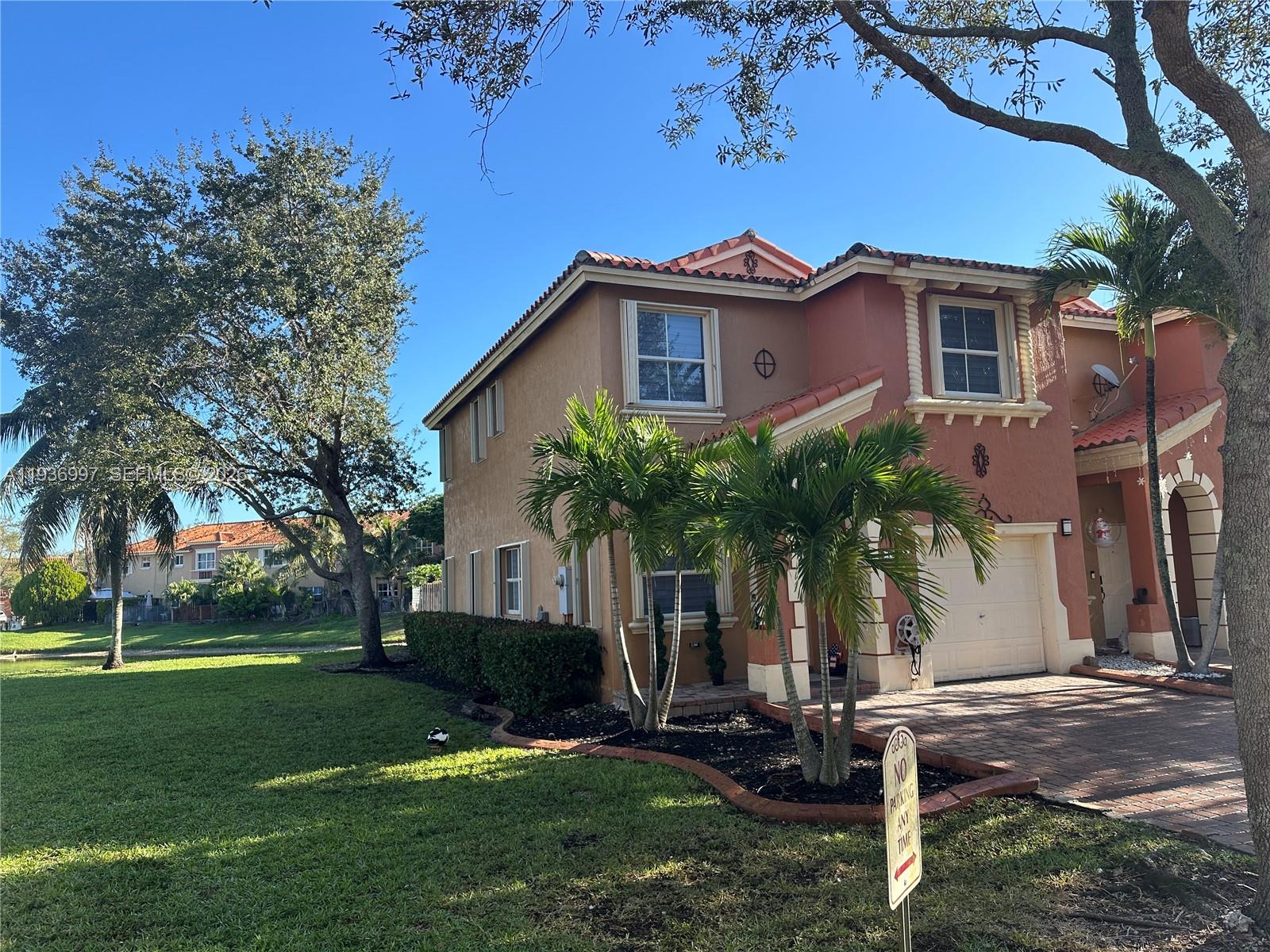 15313 Southwest 31st Terrace, Unit 15313 Miami, FL 33185 - Photo 4 of 21 a front view of a house with a yard and a garage