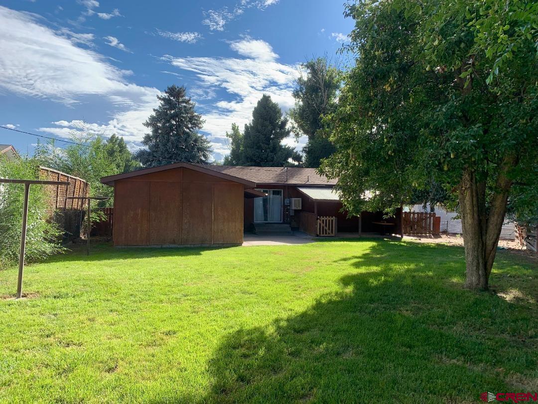 429 South San Juan Avenue Montrose, CO 81401 - Photo 1 of 18 a backyard of a house with plants and large tree