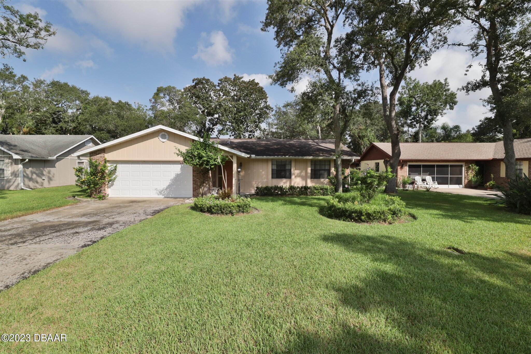 a front view of a house with a yard and trees