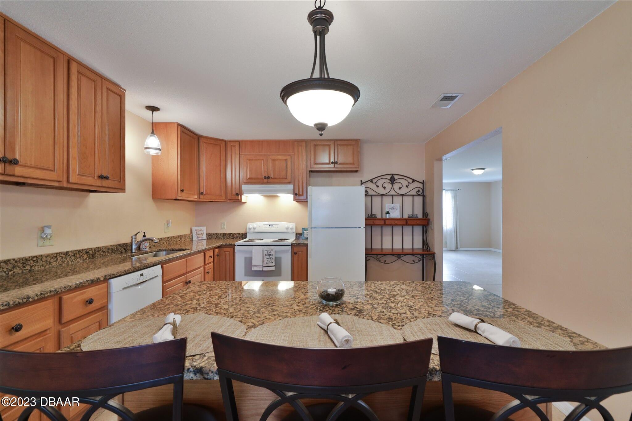 940 Northbrook Drive Ormond Beach, FL 32174 - Photo 12 of 28 a kitchen with cabinets appliances and a dining table