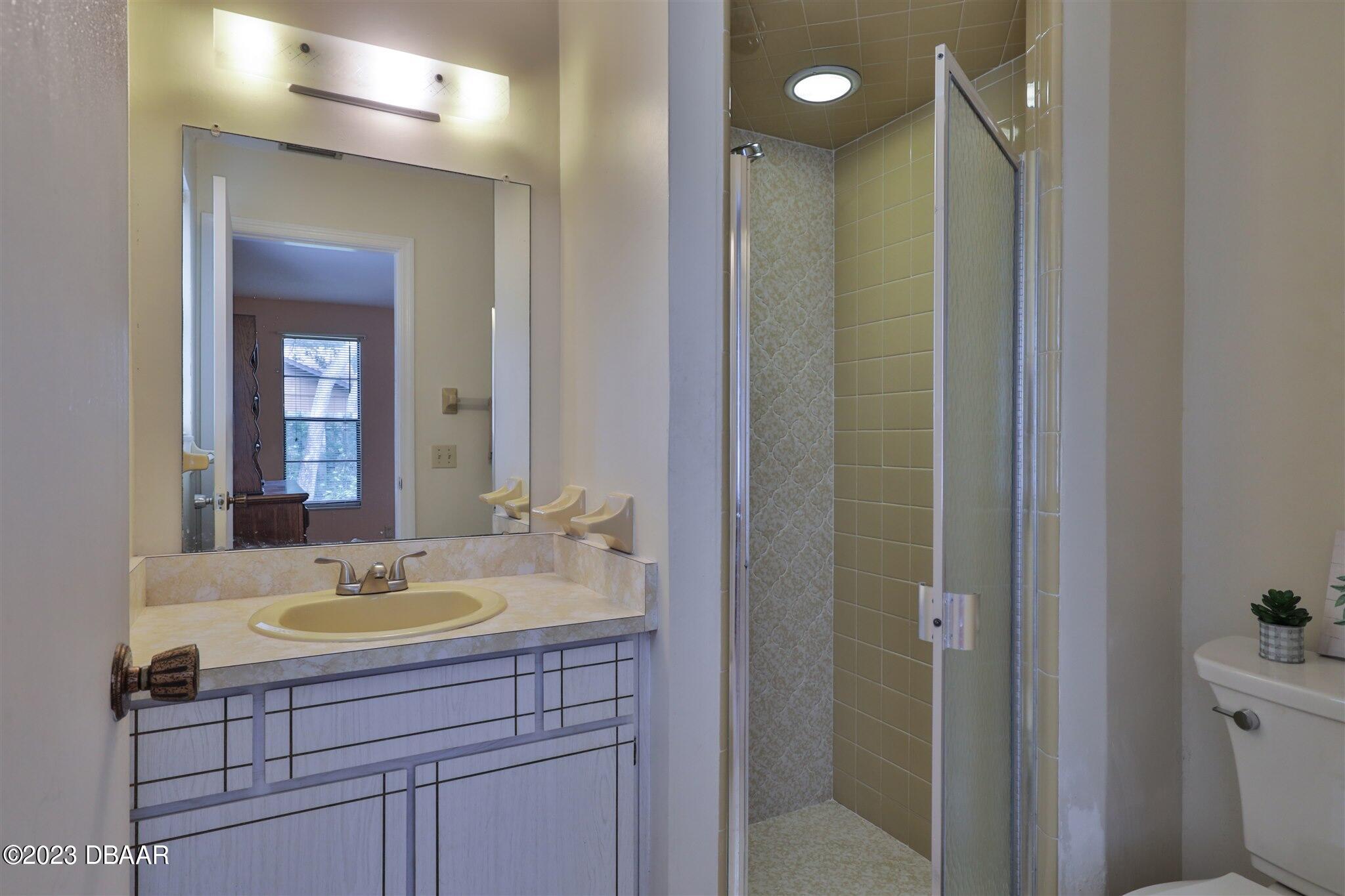 940 Northbrook Drive Ormond Beach, FL 32174 - Photo 17 of 28 a bathroom with a sink shower and a mirror