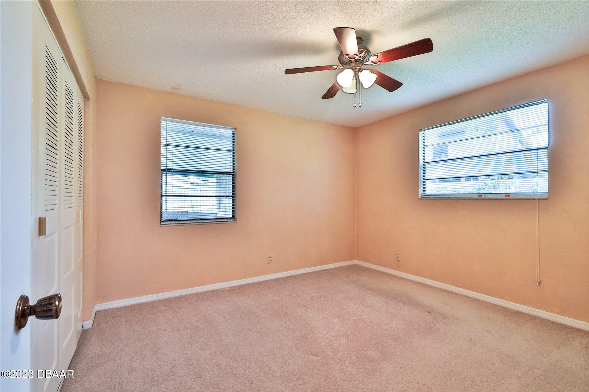 940 Northbrook Drive Ormond Beach, FL 32174 - Photo 18 of 28 an empty room with windows and ceiling fan
