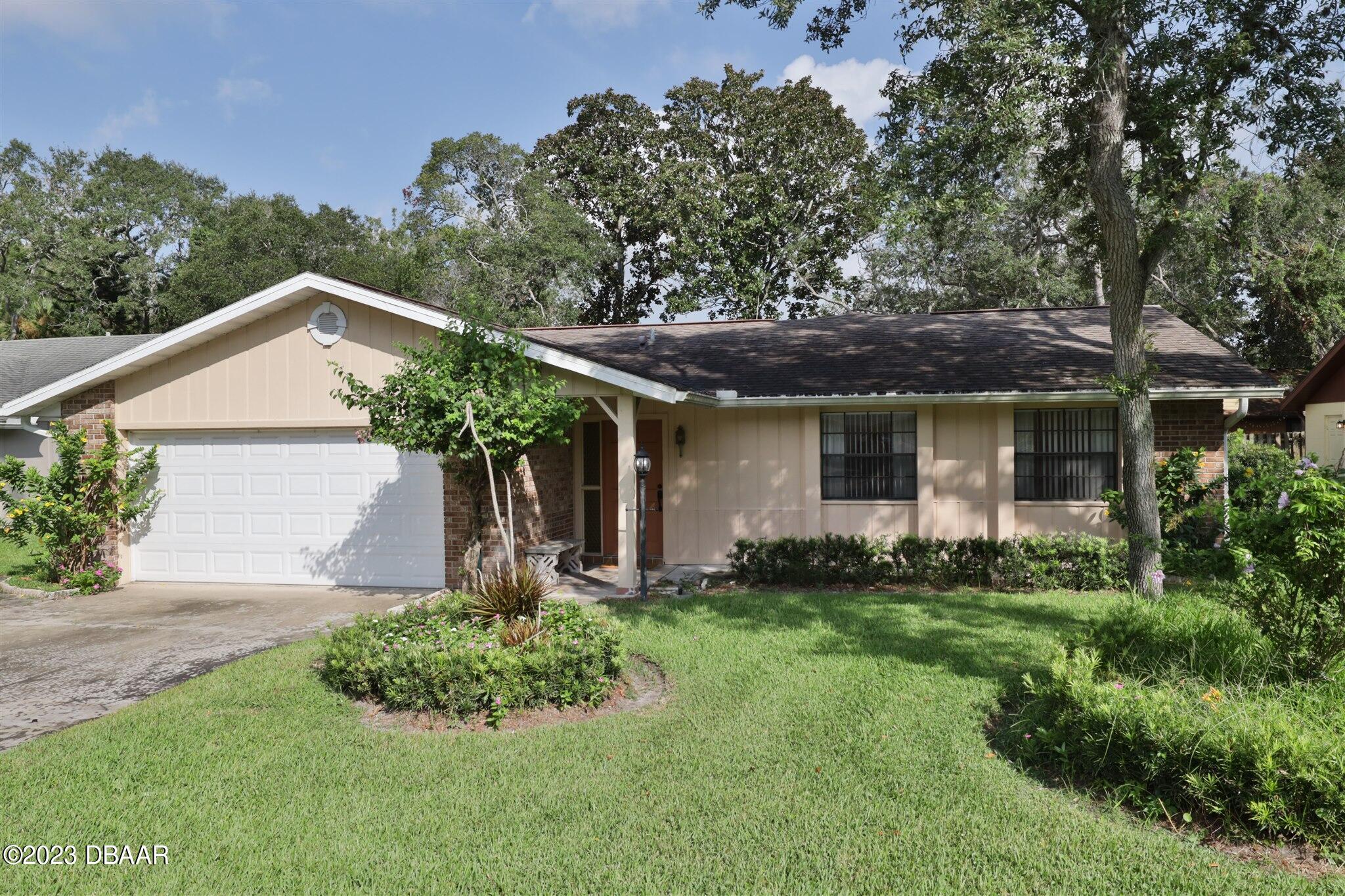 940 Northbrook Drive Ormond Beach, FL 32174 - Photo 2 of 28 a front view of a house with a yard and garage