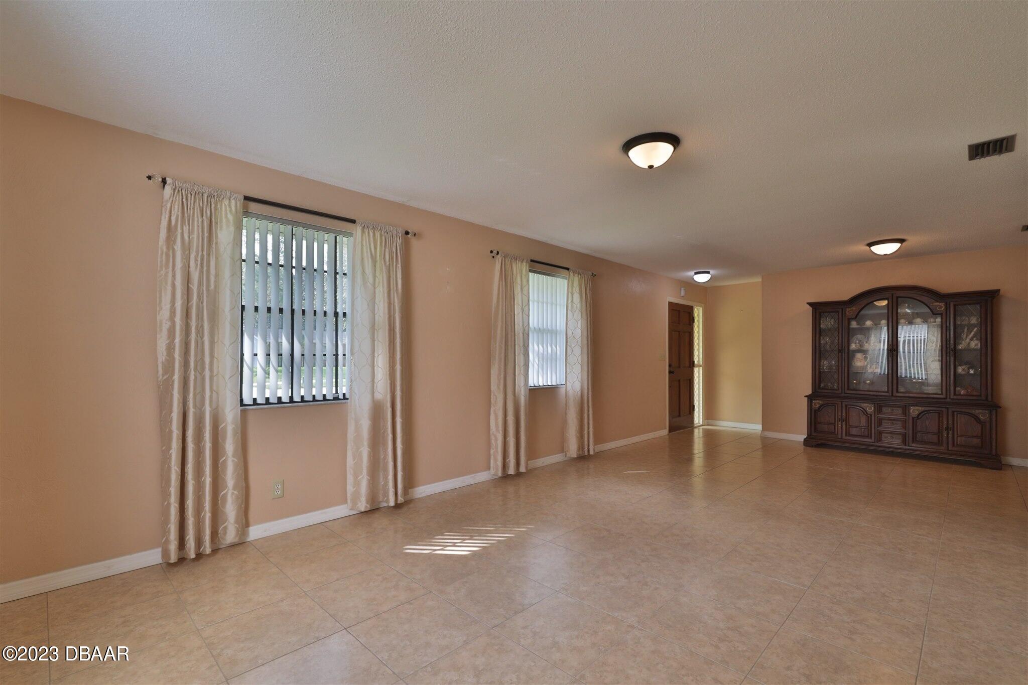 940 Northbrook Drive Ormond Beach, FL 32174 - Photo 6 of 28 an empty room with windows and cabinet