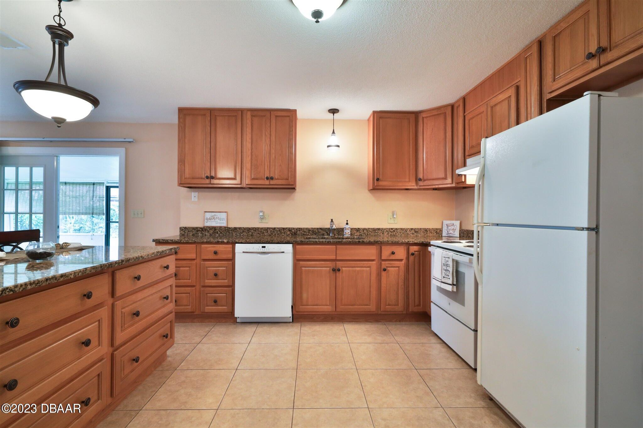940 Northbrook Drive Ormond Beach, FL 32174 - Photo 9 of 28 a kitchen with granite countertop a refrigerator and a sink