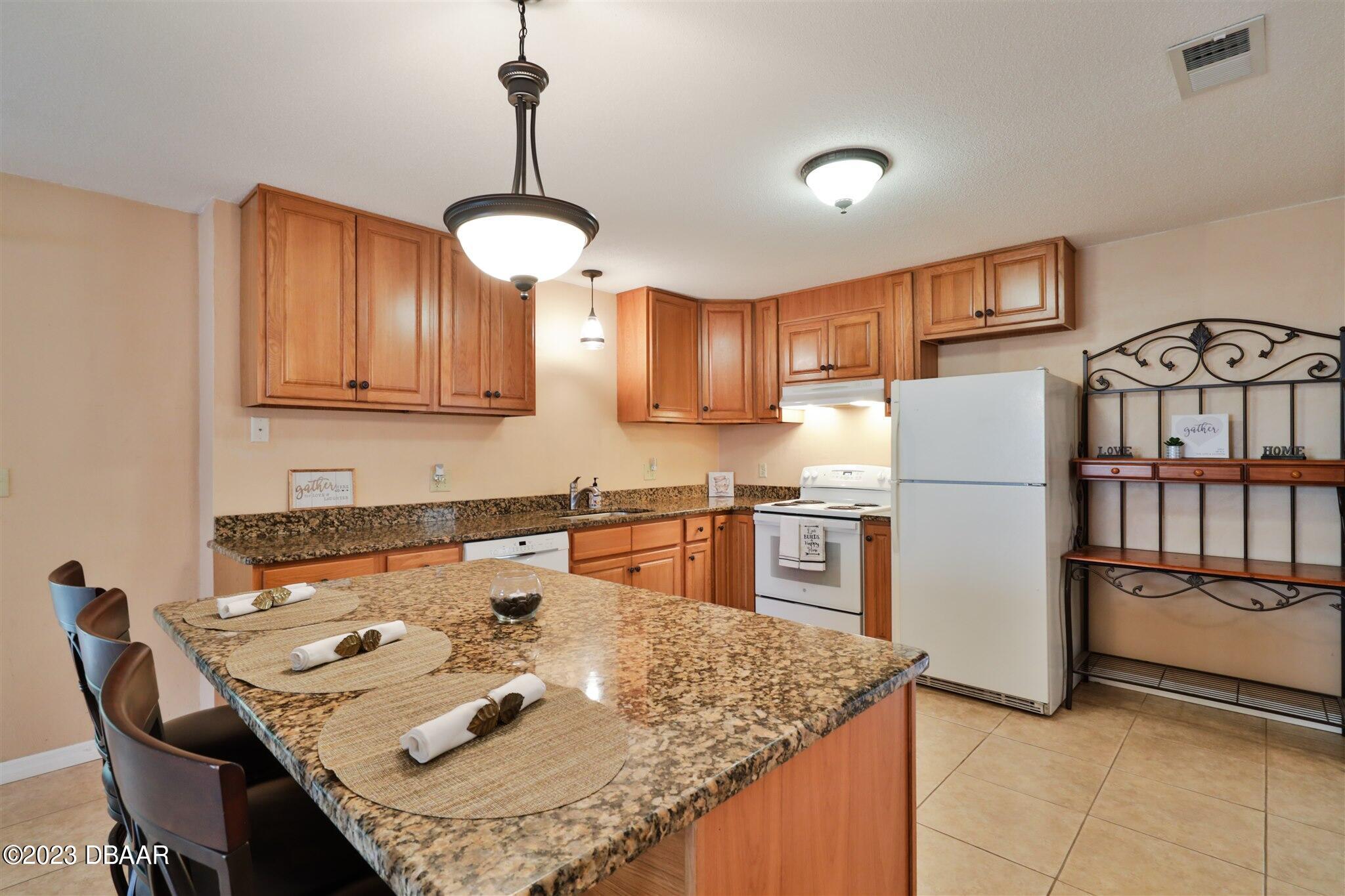 940 Northbrook Drive Ormond Beach, FL 32174 - Photo 10 of 28 a kitchen with stainless steel appliances granite countertop a sink stove and refrigerator