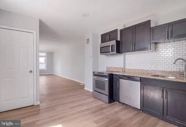 a kitchen with granite countertop stainless steel appliances and wooden cabinets