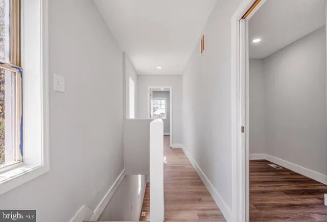 a view of a hallway with wooden floor and staircase