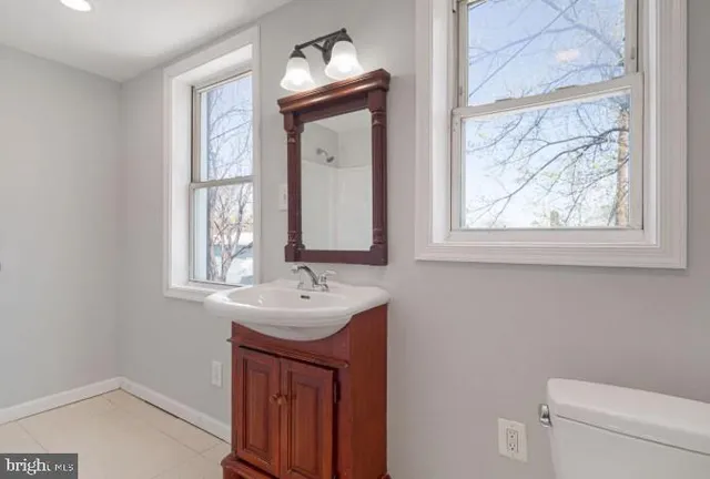 a bathroom with a sink a toilet and a window