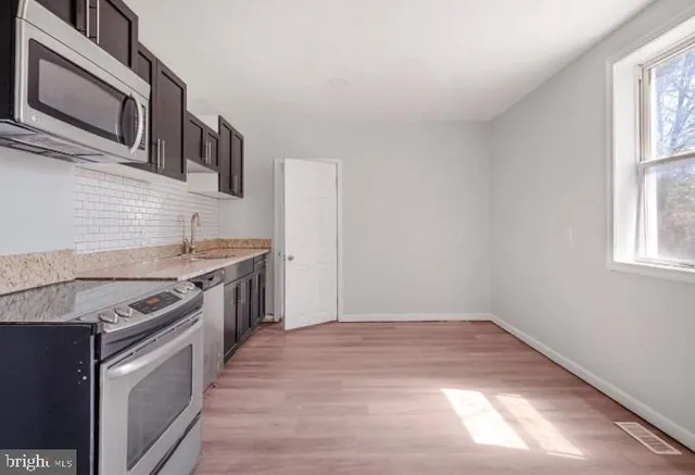 a kitchen with stainless steel appliances granite countertop a stove and a sink