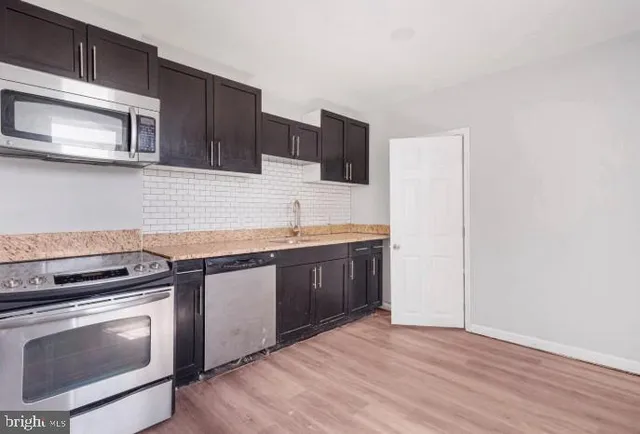 a kitchen with stainless steel appliances granite countertop a stove microwave and sink