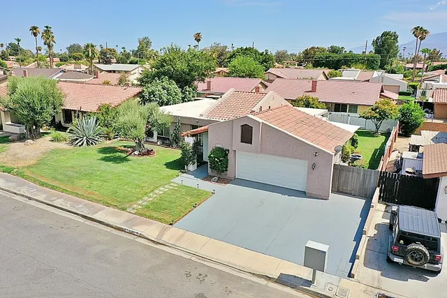 an aerial view of a house with a garden and trees