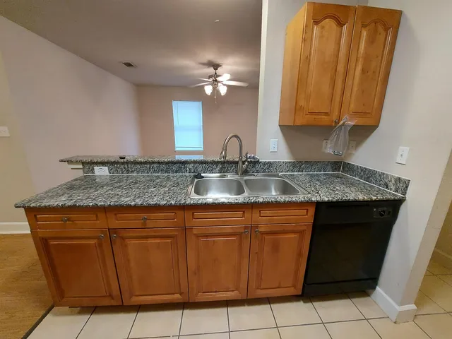 a kitchen with a sink a counter top space and cabinets