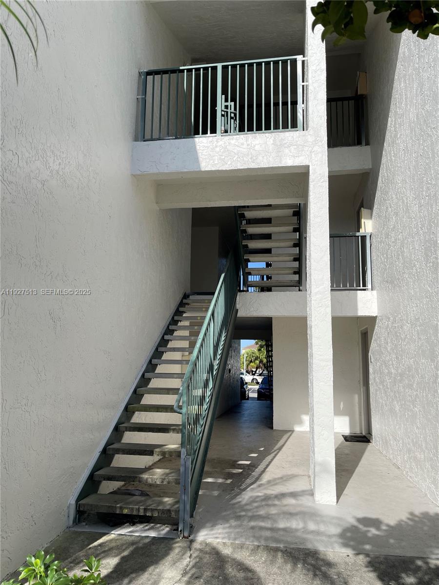 5686 Rock Island Road, Unit 114 Tamarac, FL 33319 - Photo 2 of 32 a view of staircase with lots of frames on wall and a potted plant