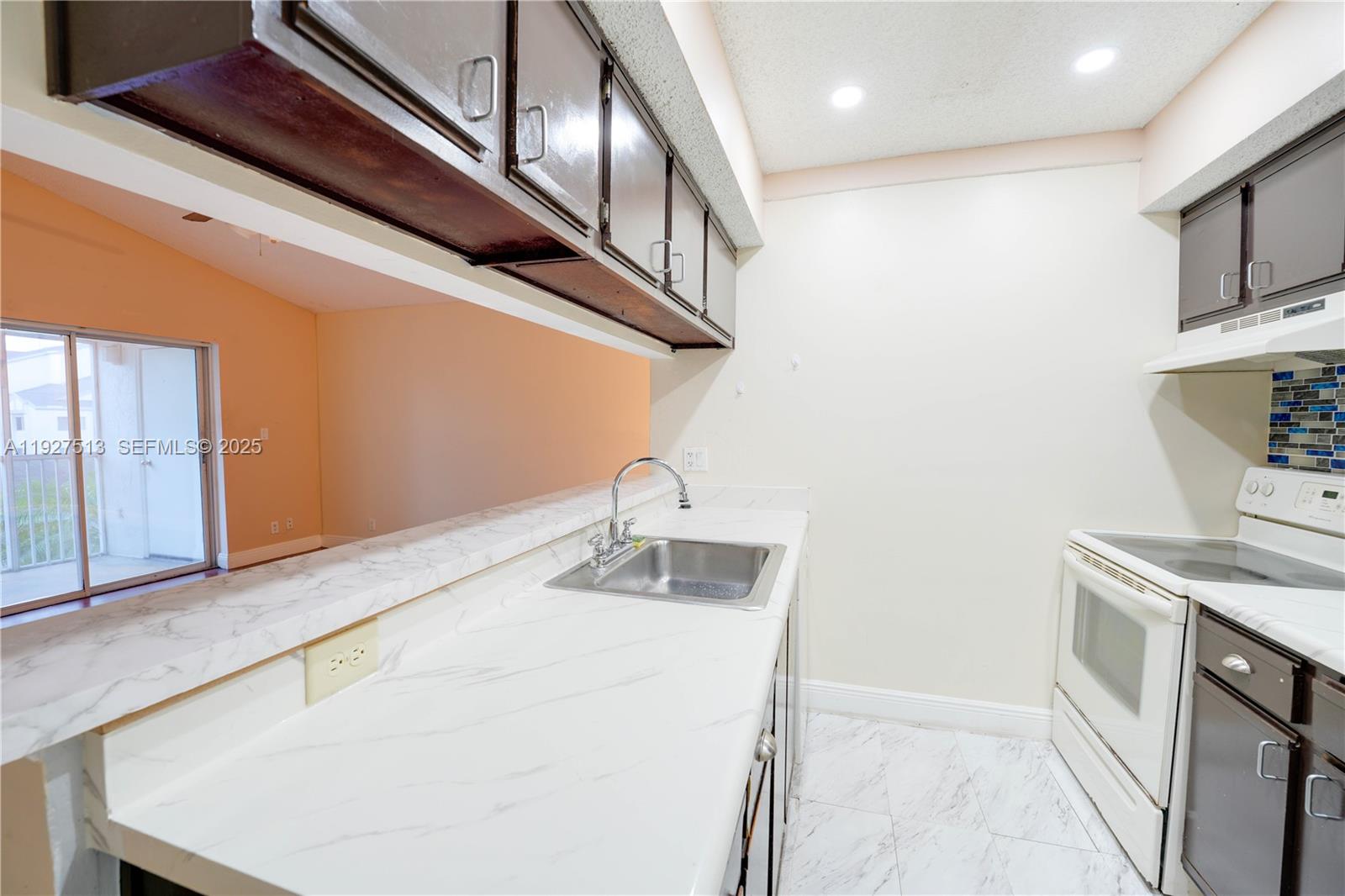 5686 Rock Island Road, Unit 114 Tamarac, FL 33319 - Photo 6 of 32 a kitchen with stainless steel appliances granite countertop a sink and a stove