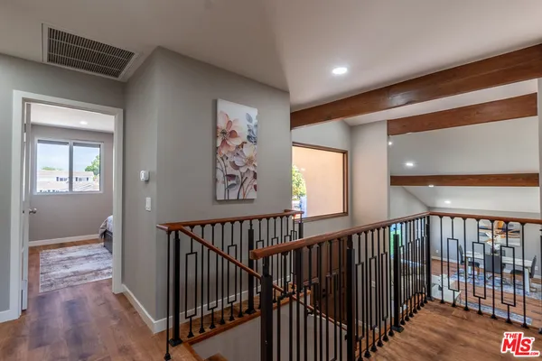 a view of a hallway with entryway and wooden floor