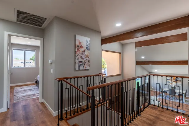 a view of a hallway with entryway and wooden floor