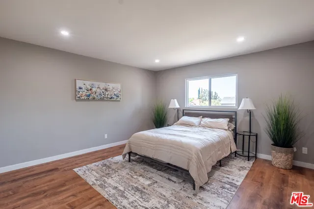 a bedroom with a large bed and a potted plant