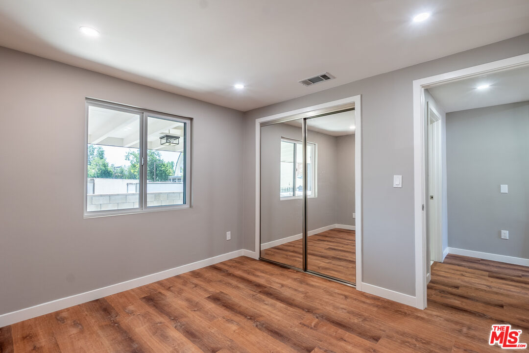 20456 Strathern Street Winnetka, CA 91306 - Photo 22 of 37 a view of an empty room with wooden floor and a window