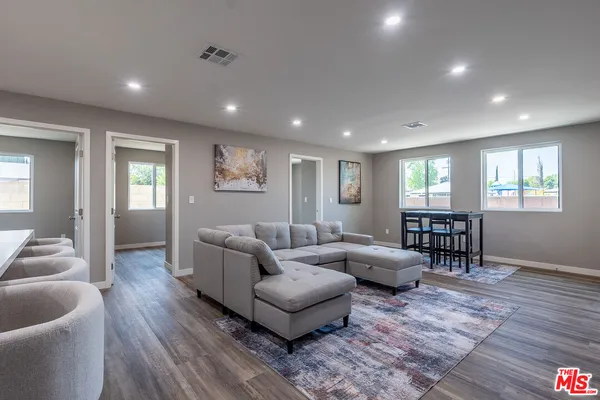 a living room with furniture and a wooden floor