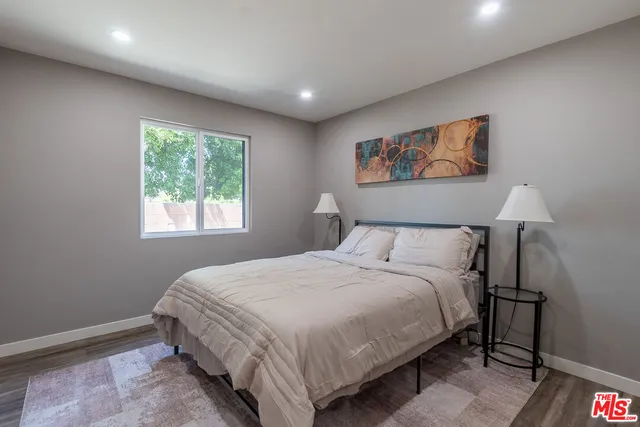 a bedroom with a bed and a painting on the wall