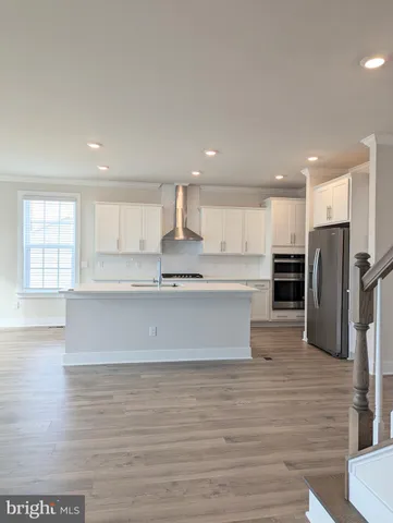 a view of a refrigerator in kitchen and white cabinets