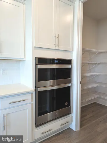 a kitchen with white cabinets and refrigerator