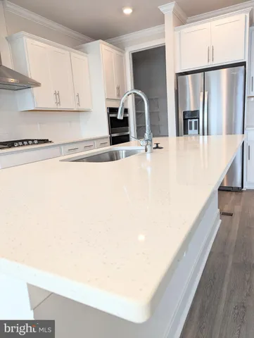 an empty room with wooden floor cabinet and windows