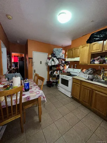 a kitchen with stainless steel appliances a stove a sink cabinets and a dining table