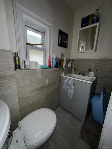 a bathroom with a toilet sink and mirror