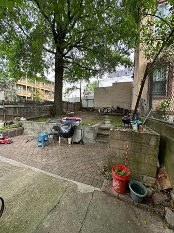 a view of a backyard with table and chairs and potted plants