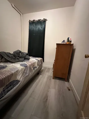 a bedroom with a bed and a refrigerator