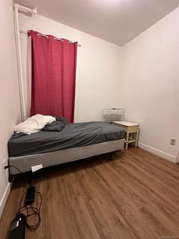 a room with a bed and a wooden floor