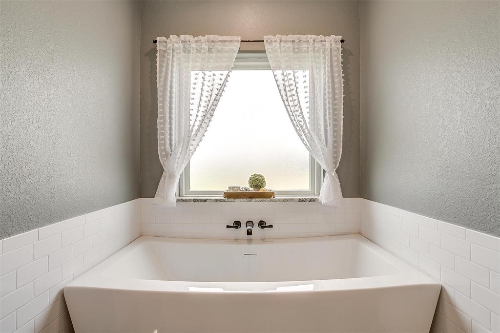 3095 County Road 905 Joshua, TX 76058 - Photo 14 of 38 a bath tub sitting in a bathroom next to a window