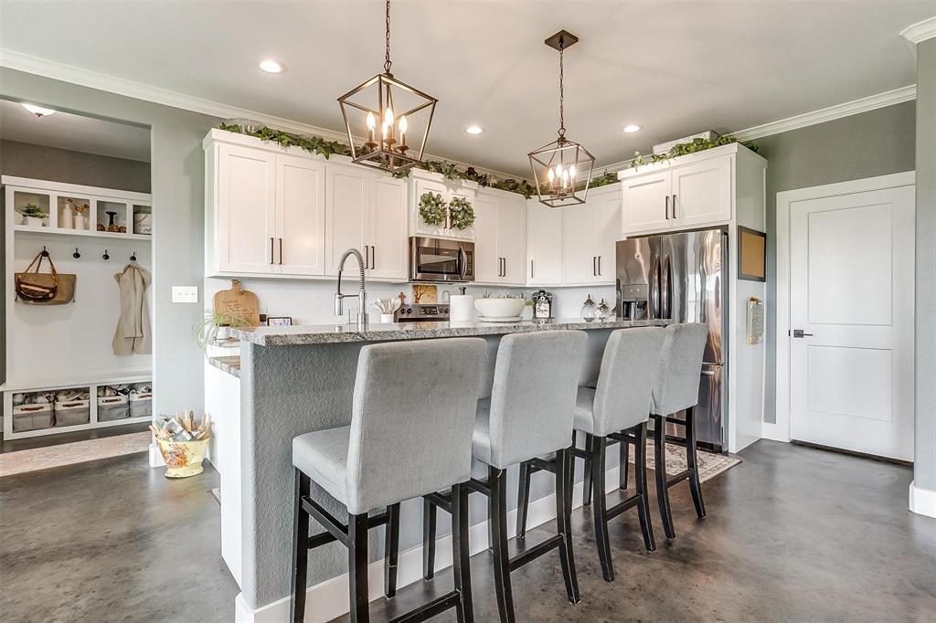 3095 County Road 905 Joshua, TX 76058 - Photo 7 of 38 a kitchen with kitchen island a dining table chairs stainless steel appliances and cabinets