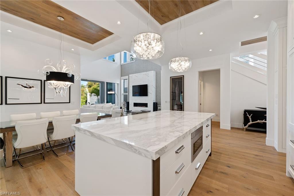 770 Park Street Naples, FL 34102 - Photo 5 of 34 a large white kitchen with a large island oven a stove dining table and chairs