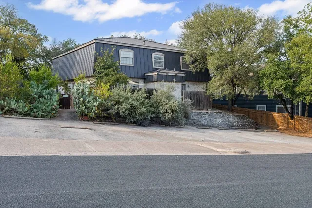 a front view of a house with a yard and potted plants