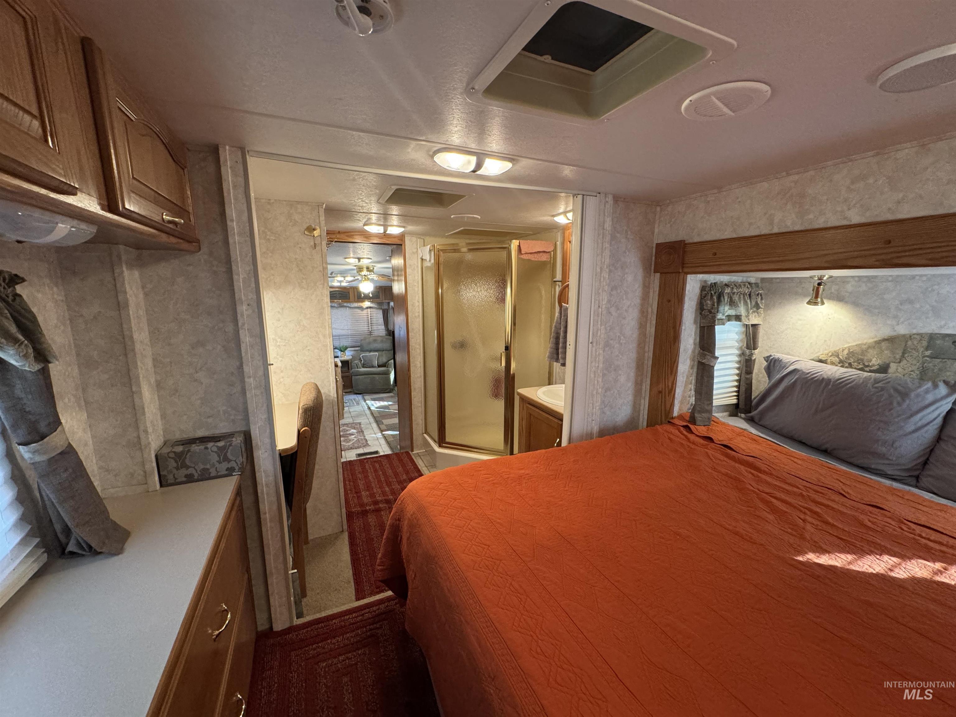 29 B Street Cascade, ID 83611 - Photo 9 of 24 Carpeted bedroom featuring attic access, wallpapered walls, and connected bathroom