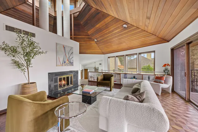 a living room with furniture fireplace and a large window
