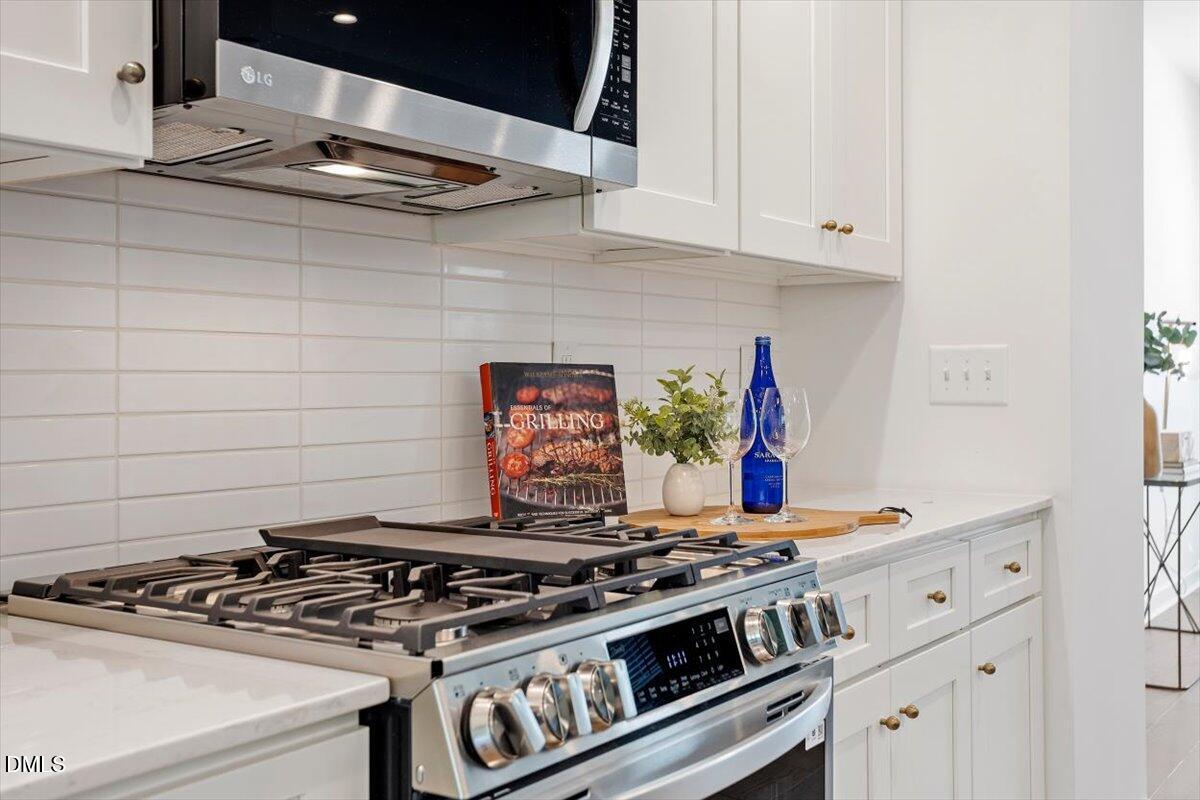 6419 Tanner Oak Lane Raleigh, NC 27613 - Photo 13 of 39 a stove top oven sitting inside of a kitchen