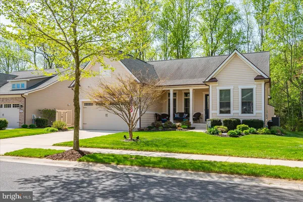 a front view of a house with a yard and trees