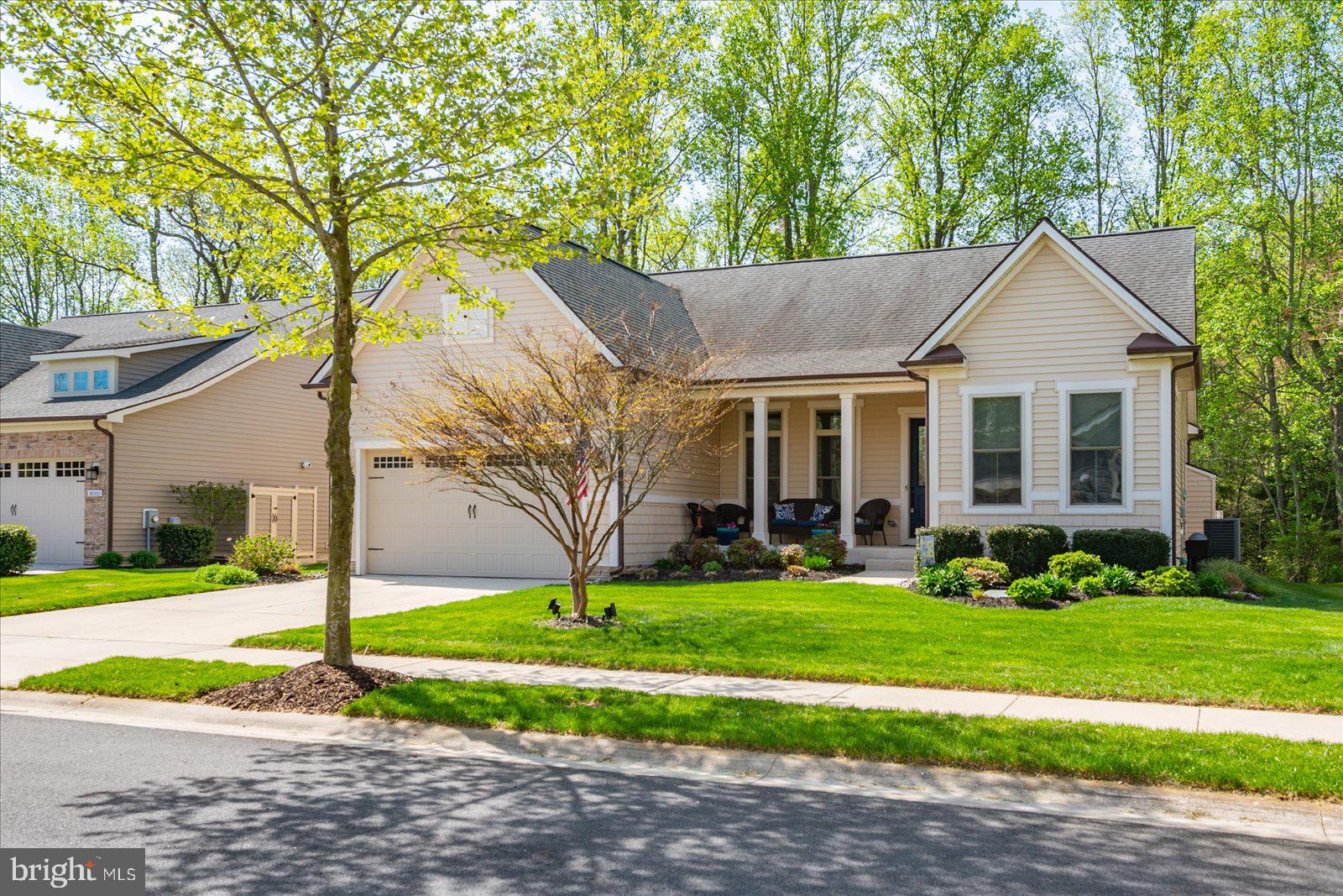 a front view of a house with a yard and trees