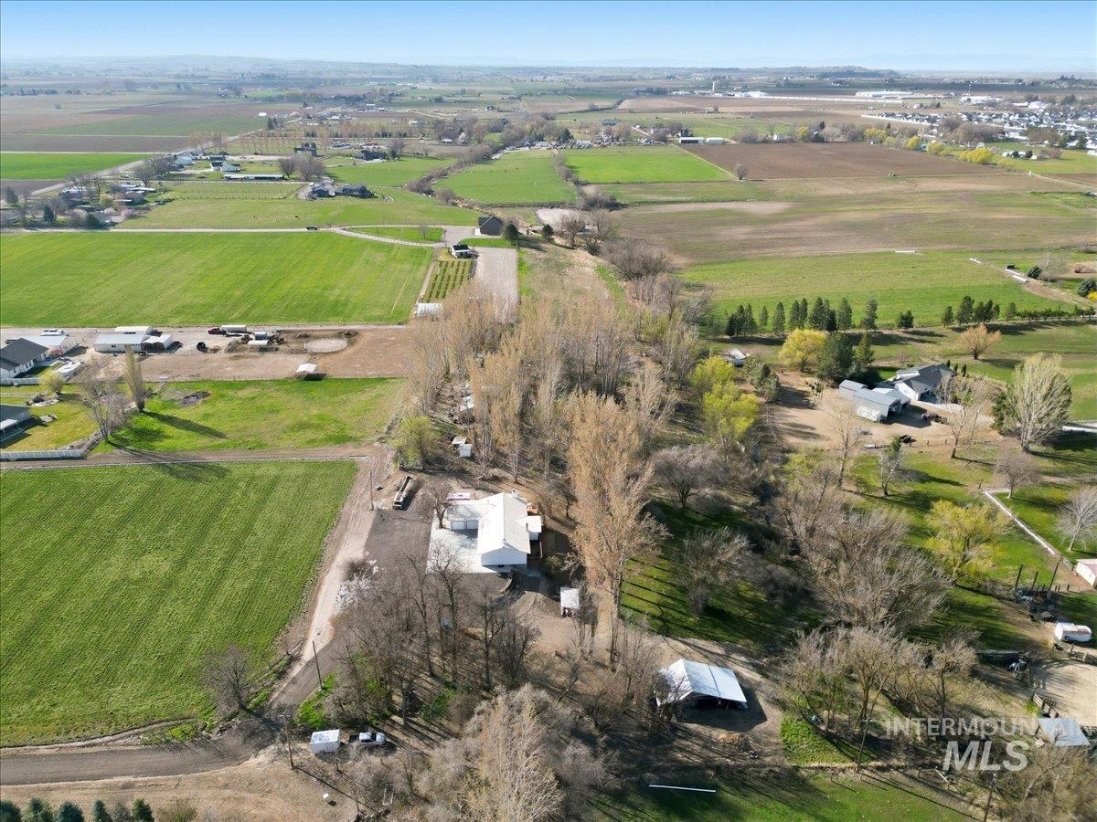7771 Elmore Road Fruitland, ID 83619 - Photo 48 of 48 Expansive agricultural landscape featuring green fields, scattered residential structures, mature trees, and a distant town