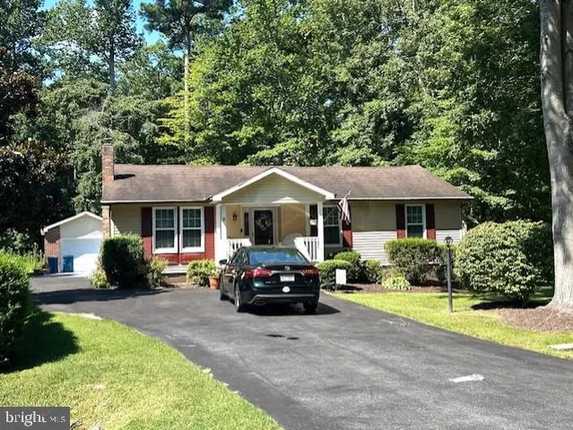 a view of a house with a yard and large trees