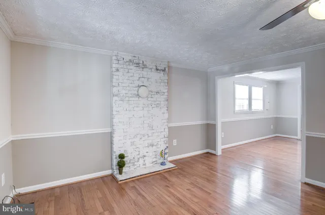 an empty room with wooden floor closet and windows
